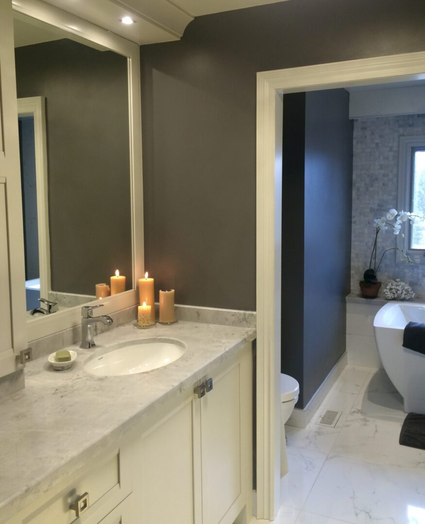 A white color bathroom with basin and candles