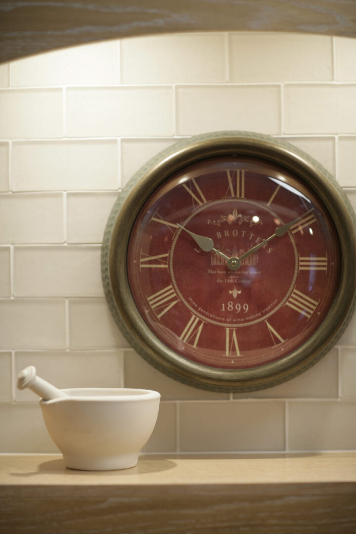A clock with a kitchen vessel near it