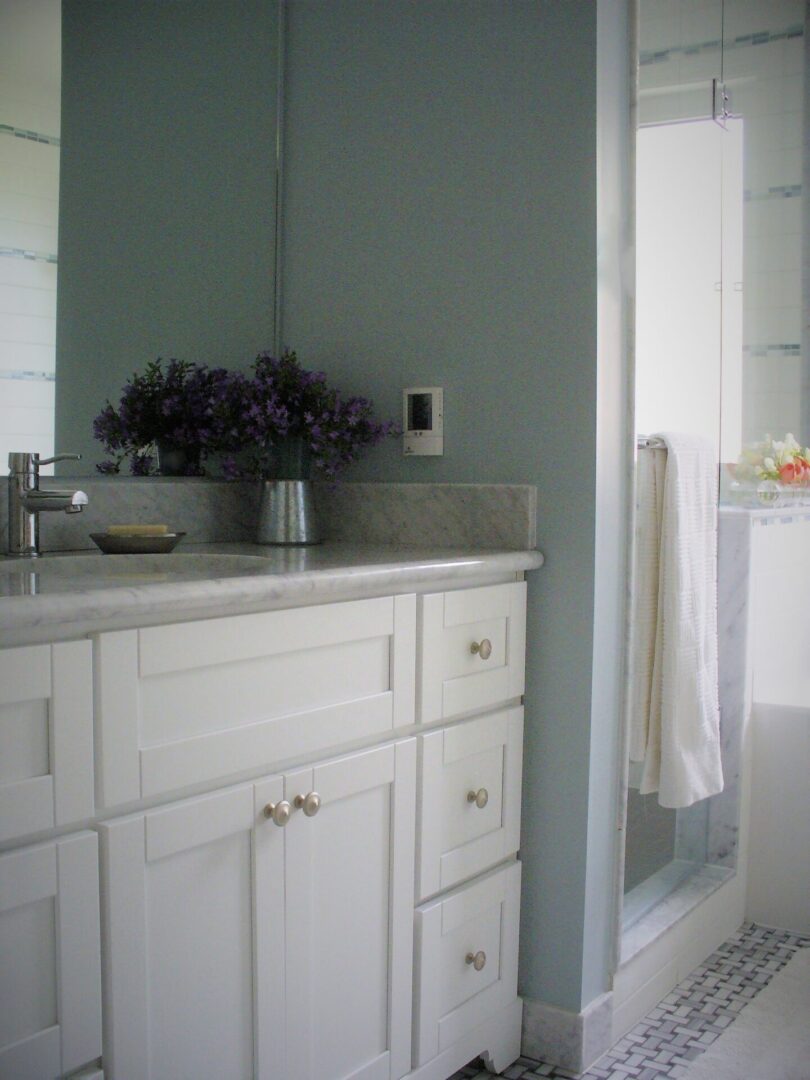 A bathroom with glass door and basin